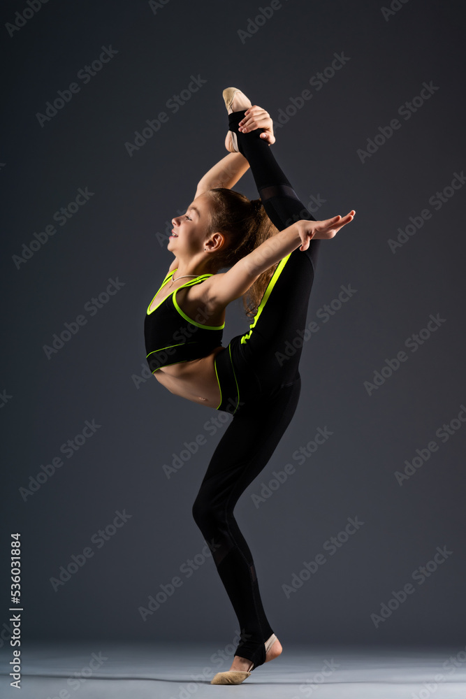 Young gymnast. A teenage girl in a tracksuit is engaged in gymnastics