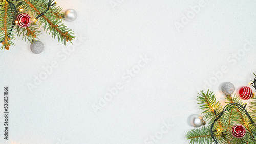 Pine bracnhes decorated with red and silver ornaments on white background. Flat lay copy space photo