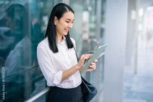 Asian businesswoman holding a tablet looking smile , smart business concept, smart woman .