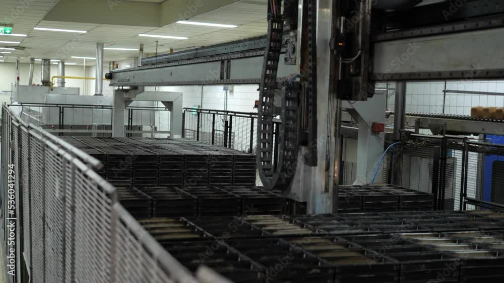 Robot picks up bakery plates and moves them in a bakery factory Robot picks up bakery plates and moves them in a bakery factory