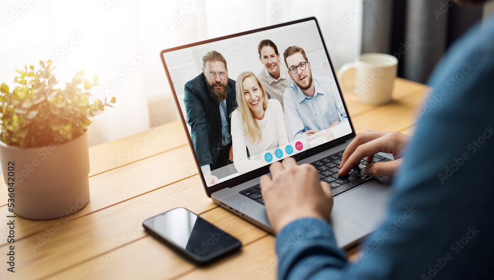 Laptop screen view over man shoulder at group video call. Communication between business people distantly using webcam internet connection app. Working remote chat concept Laptop screen view over man shoulder at group video call. Communication between business people distantly using webcam internet connection app. Working remote chat concept