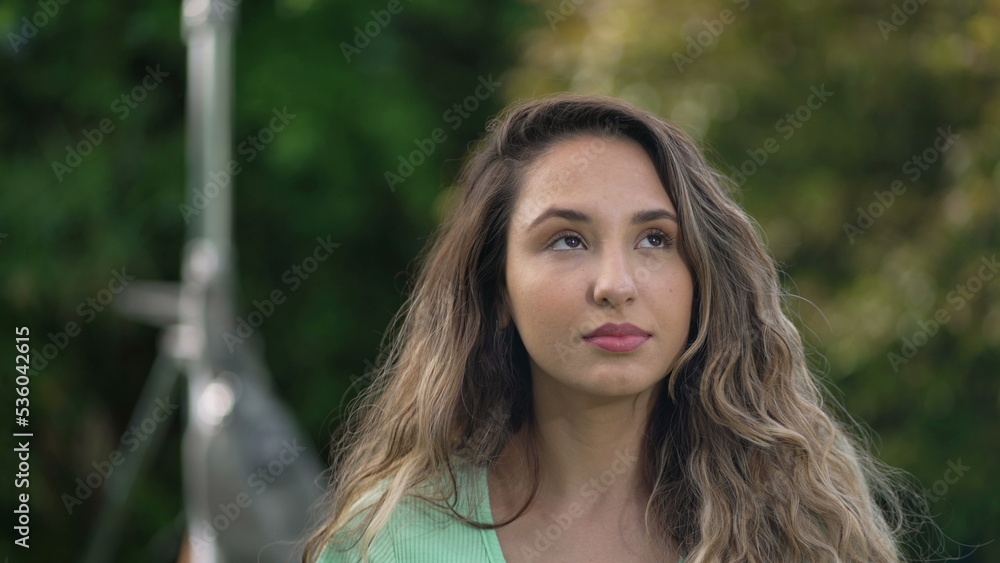 Naklejka premium One hopeful hispanic young woman looking up at sky with FAITH. Spiritual South American female person 2