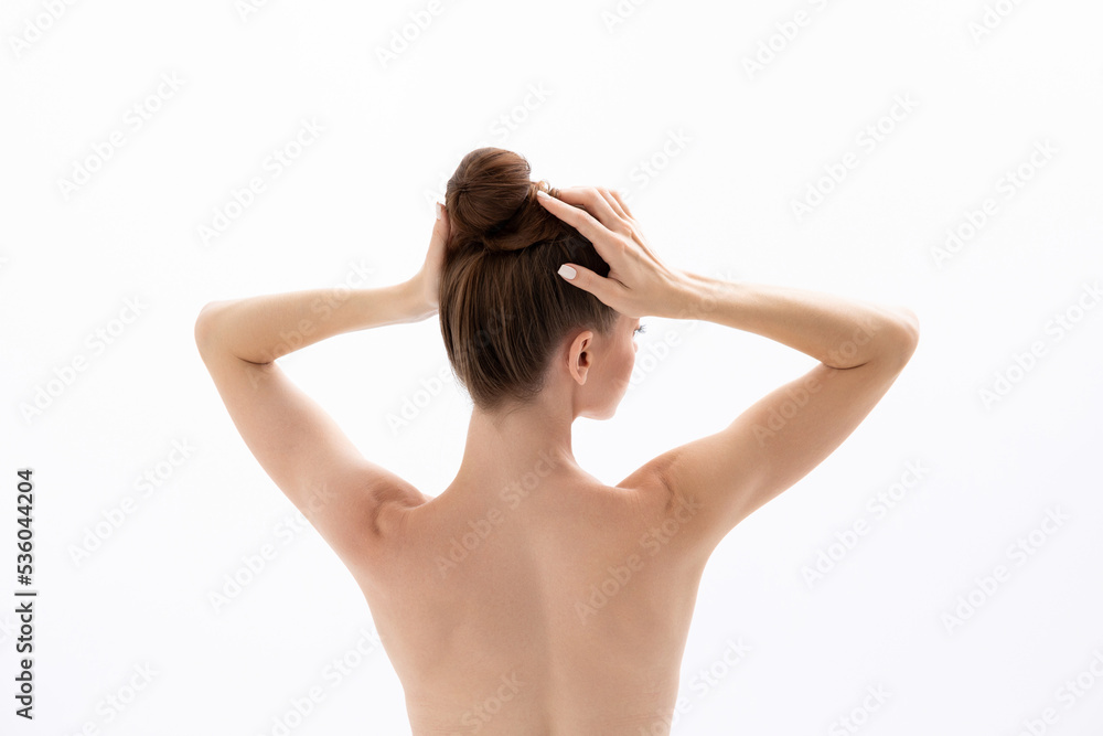 A young woman touches her head and demonstrates products for hair and skin. A young woman touches her head and demonstrates products for hair and skin.