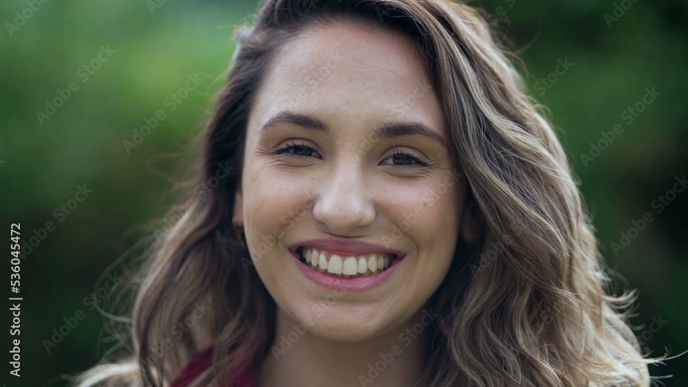 Happy hispanic young woman smiling standing outdoors. One millennial South American girl feeling excited 2 Happy hispanic young woman smiling standing outdoors. One millennial South American girl feeling excited 2
