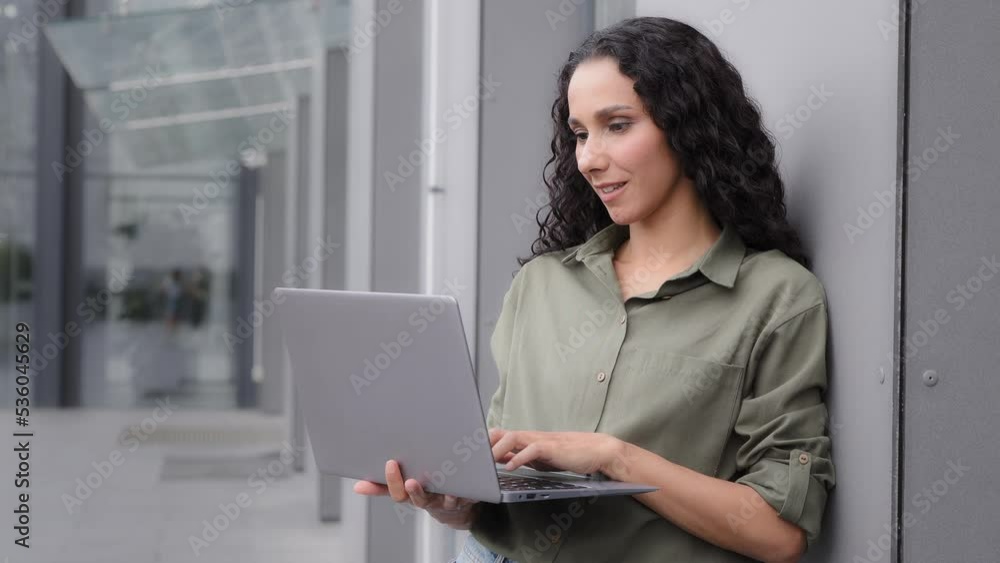 Closeup 30s woman user professional specialist worker manager freelancer businesswoman lady architect female business consultant student investor with laptop work online outdoors in city near building Closeup 30s woman user professional specialist worker manager freelancer businesswoman lady architect female business consultant student investor with laptop work online outdoors in city near building