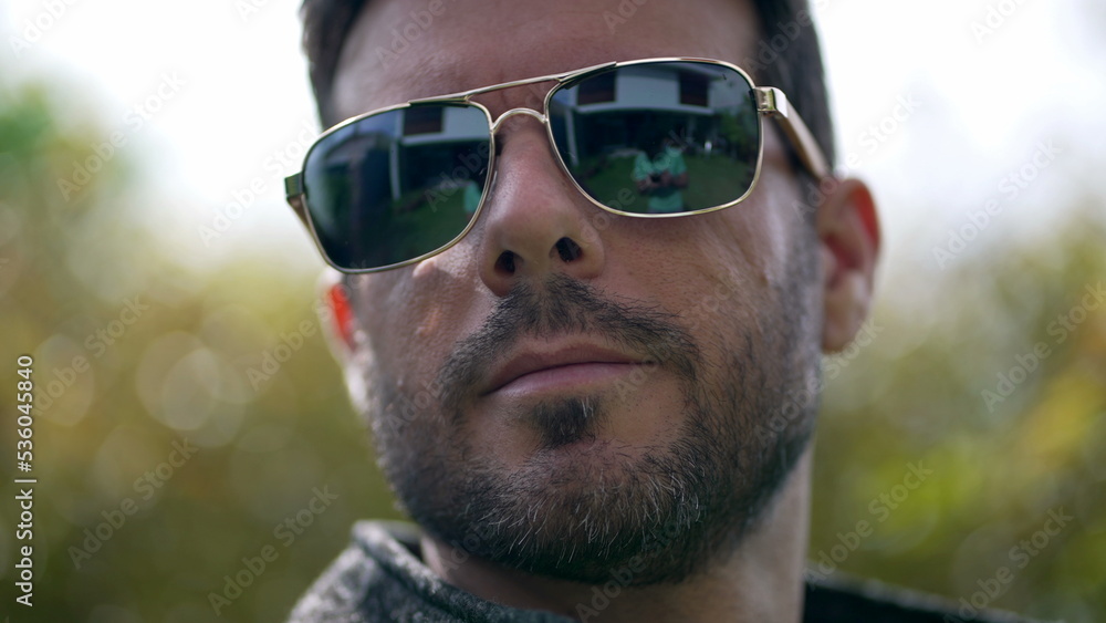 Handsome young man wearing sunglasses outdoors. Closeup face of male person with eye glass Handsome young man wearing sunglasses outdoors. Closeup face of male person with eye glass