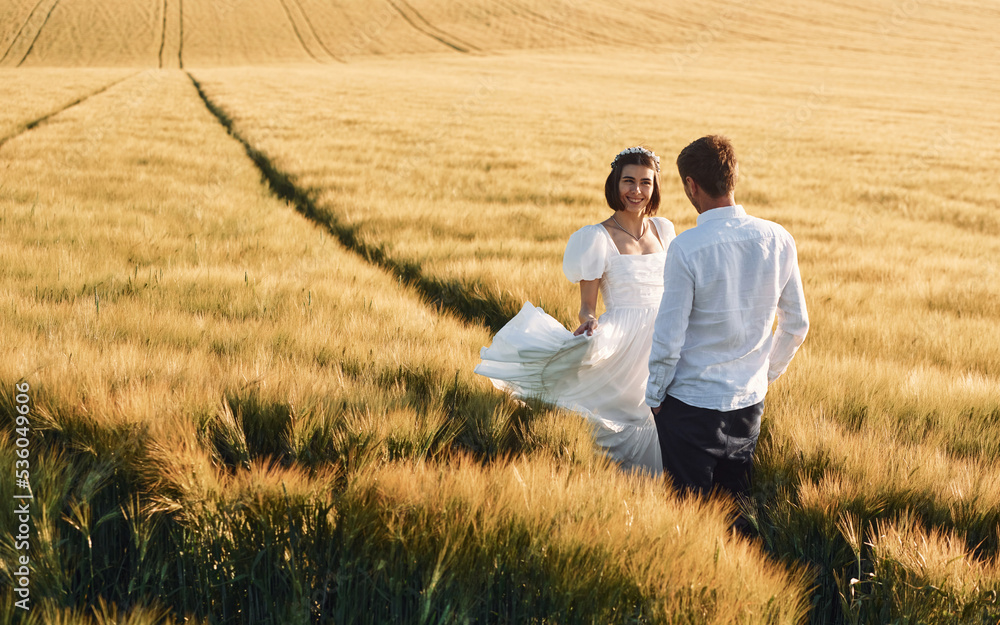 Enjoying the walk. Couple just married. Together on the majestic agricultural field at sunny day