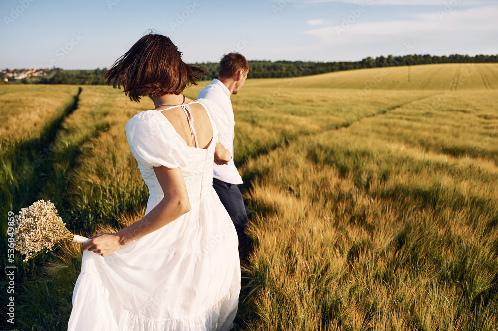 Conception of love. Couple just married. Together on the majestic agricultural field at sunny day