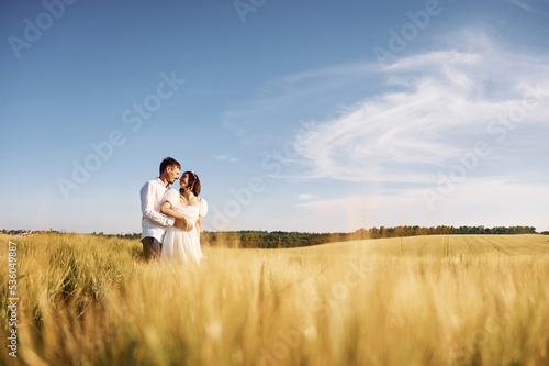 Standing and enjoying the nature. Couple just married. Together on the majestic agricultural field at sunny day