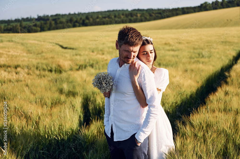 Beautiful sunlight. Couple just married. Together on the majestic agricultural field Beautiful sunlight. Couple just married. Together on the majestic agricultural field