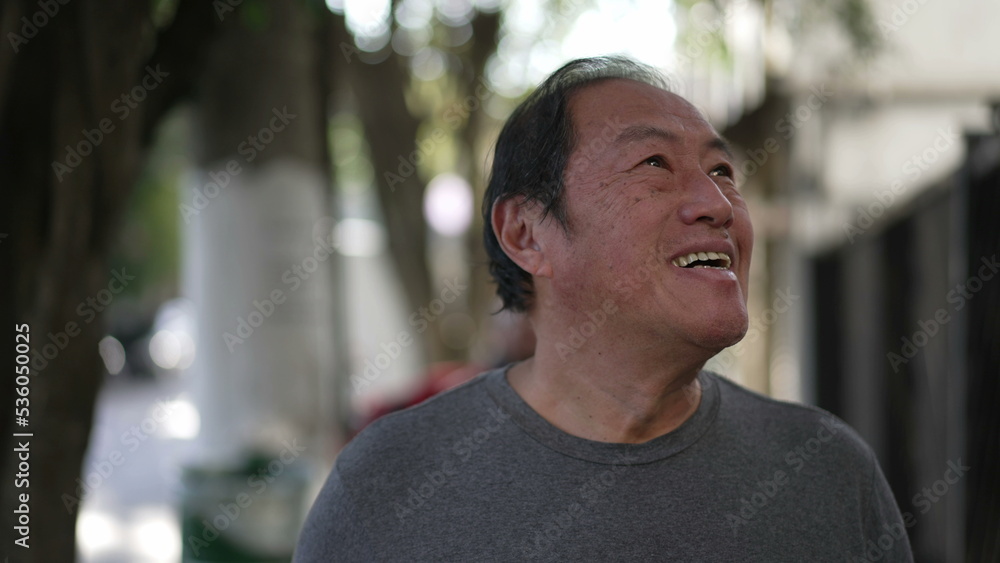 One joyful Asian man walking outside smiling in city street. Portrait of a smiling happy older middle aged Japanese male in urban sidewalk One joyful Asian man walking outside smiling in city street. Portrait of a smiling happy older middle aged Japanese male in urban sidewalk