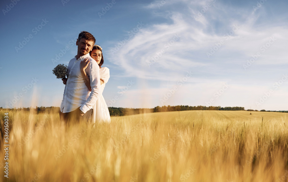 Beautiful sunlight. Couple just married. Together on the majestic agricultural field Beautiful sunlight. Couple just married. Together on the majestic agricultural field