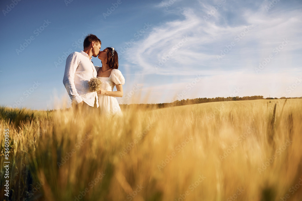 Embracing each other. Couple just married. Together on the majestic agricultural field at sunny day Embracing each other. Couple just married. Together on the majestic agricultural field at sunny day
