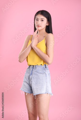 Asian girl in summer dress on pink background