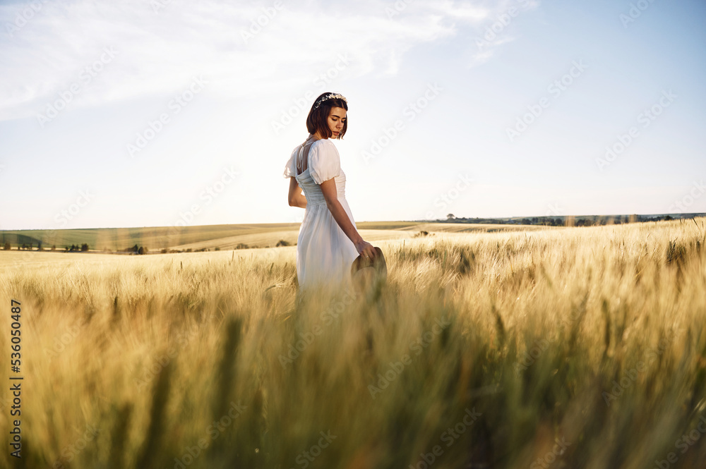 Enjoying the nature. Beautiful young bride in white dress is on the agricultural field at sunny day Enjoying the nature. Beautiful young bride in white dress is on the agricultural field at sunny day