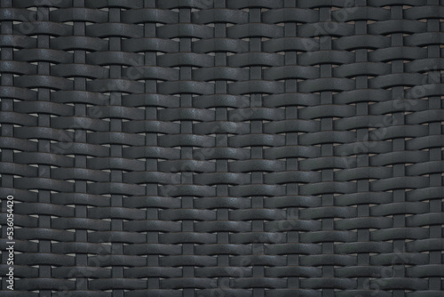 close up pattern of black plastic rattan modern furniture material background. for weave wallpaper backdrop design.
