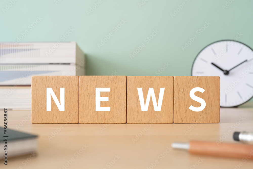 Foto NEWSと書かれたブロックが置かれたデスク
