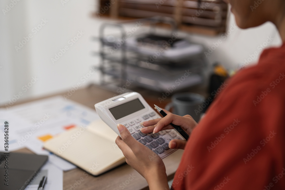 Asian Business woman calculating saving account balance with working at home, account and saving concept Asian Business woman calculating saving account balance with working at home, account and saving concept