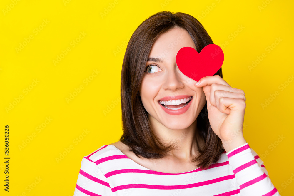 Photo of nice cute gorgeous woman with bob hairdo striped shirt look empty space hold heart close eye isolated on yellow color background Photo of nice cute gorgeous woman with bob hairdo striped shirt look empty space hold heart close eye isolated on yellow color background