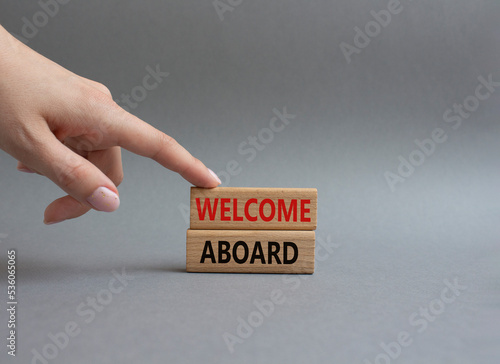 Welcome aboard symbol. Concept word Welcome aboard on wooden blocks. Beautiful green background. Businessman hand. Business and Welcome aboard concept. Copy space