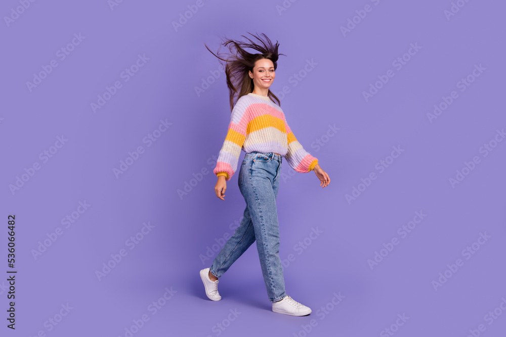 Full size profile photo of charming cheerful person flying hair walking isolated on violet color background Full size profile photo of charming cheerful person flying hair walking isolated on violet color background