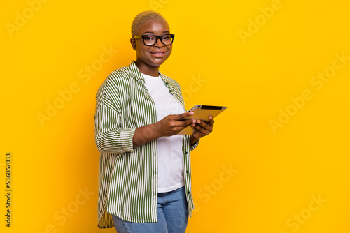 Photo of charming pretty person hands hold tablet toothy smile isolated on yellow color background