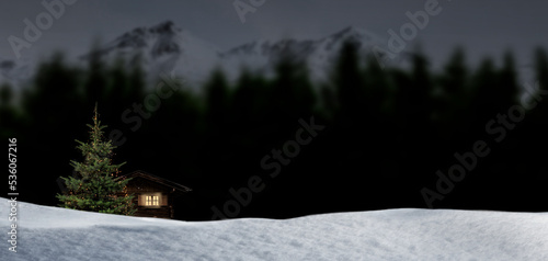 Dekorierter Weihnachtsbaum vor einer Schihütte in den Bergen