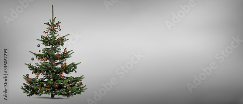 Freigestellter dekorierter Weihnaachtsbaum vor grauem Hintergrund