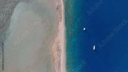 High angle aerial drone flight over Langford Island, a small islet next to Hayman Island, a luxury resort hotel in the Whitsunday Islands group near the Great Barrier Reef in Queensland, Australia. photo