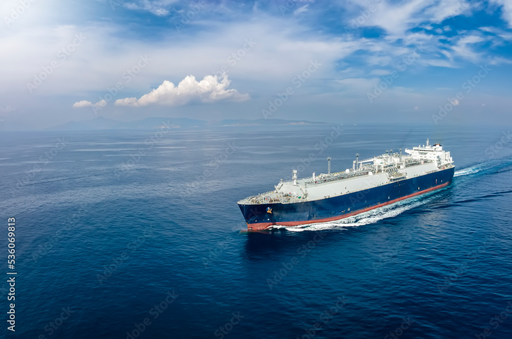 Front view of a big LNG tanker ship travelling over the calm, blue ocean as a concept for international fuel industry with copy space - obrazy, fototapety, plakaty 