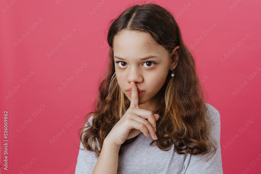 Young beautiful long-haired girl in blue t-shirt showing silence gesture Young beautiful long-haired girl in blue t-shirt showing silence gesture
