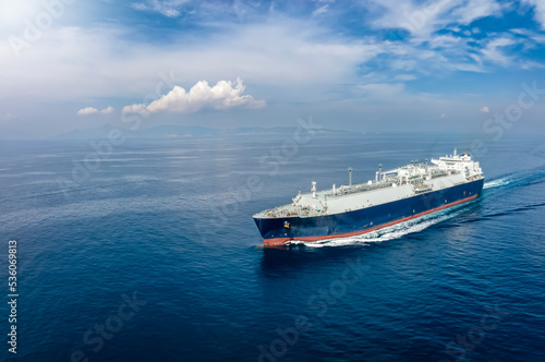 Front view of a big LNG tanker ship travelling over the calm, blue ocean as a concept for international fuel industry with copy space