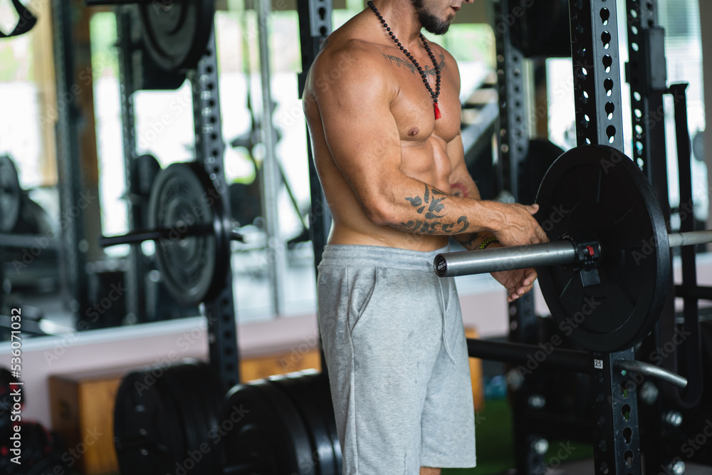 Man changing preparing the weights to lift on a bench press Man changing preparing the weights to lift on a bench press
