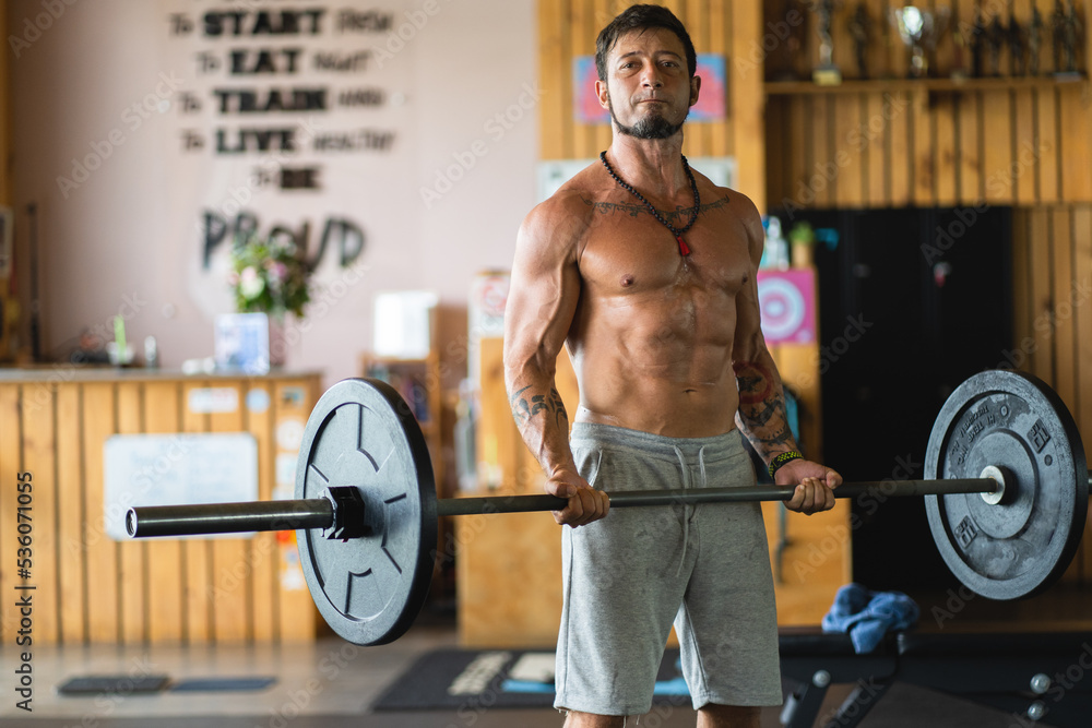 Portrait of a latin strong man lifting weights in a gym Portrait of a latin strong man lifting weights in a gym