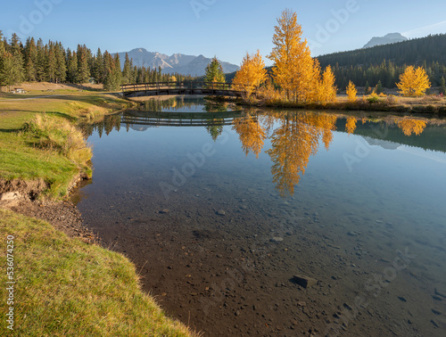Wooden footbridge and fall colors at Cascade Pond in Banff National Park