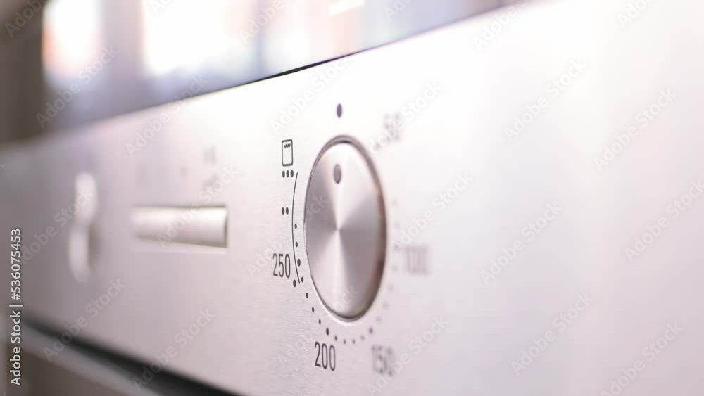 Turning the temperature switch on an electric oven. Male hand turns on the oven close-up. Setting modes for cooking food. Concept of housework, restaurant, cook turns on the stove 4K footage Turning the temperature switch on an electric oven. Male hand turns on the oven close-up. Setting modes for cooking food. Concept of housework, restaurant, cook turns on the stove 4K footage
