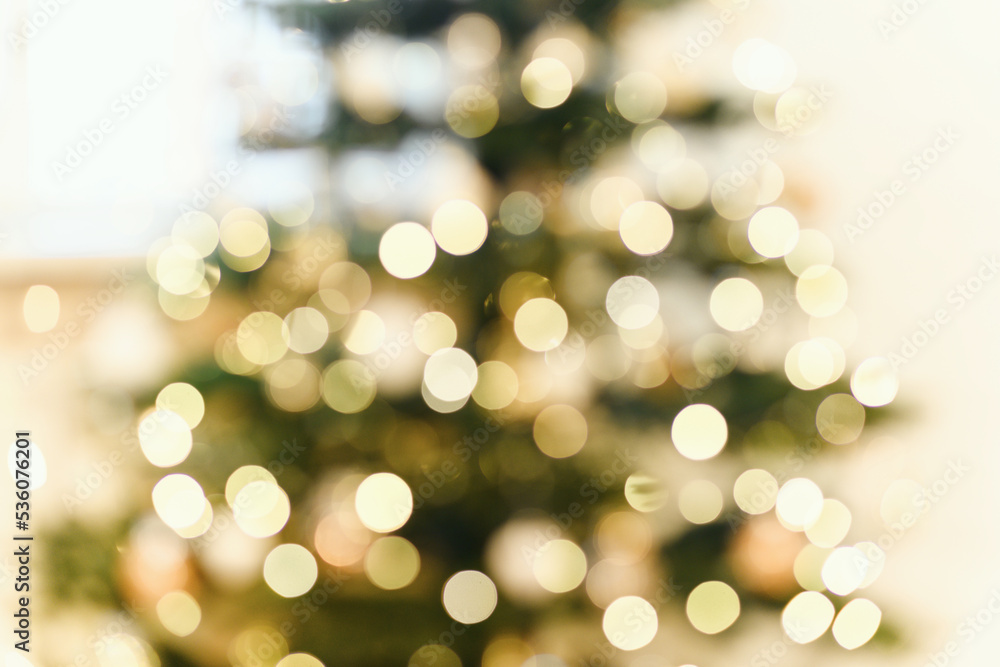 Blur background with decorates a Christmas tree with garland and ilarge transparent glass ball.