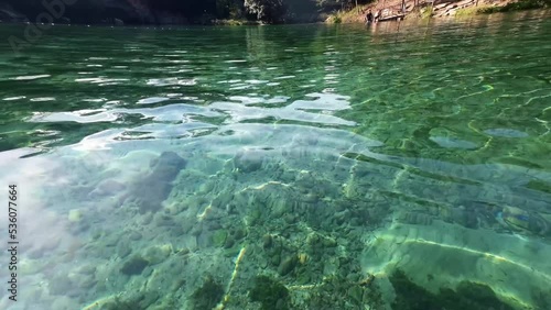 Handheld shot from inside of the water of a crystal clear natural pool inside of the Pratinha farm resort in Chapada Diamantina in Bahia, eastern Brazil on a warm summer day. photo