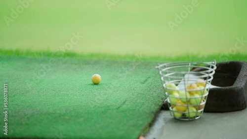 Golfer hitting a golf ball with an iron club on a driving range
