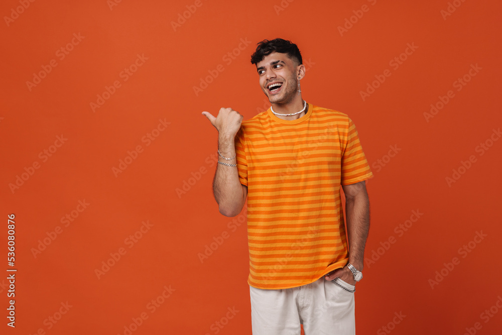 Brunette young man laughing and pointing finger aside Brunette young man laughing and pointing finger aside