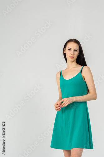 Gorgeous elegant sensual brunette young woman wearing fashion green dress on a white background © Михаил Таратонов