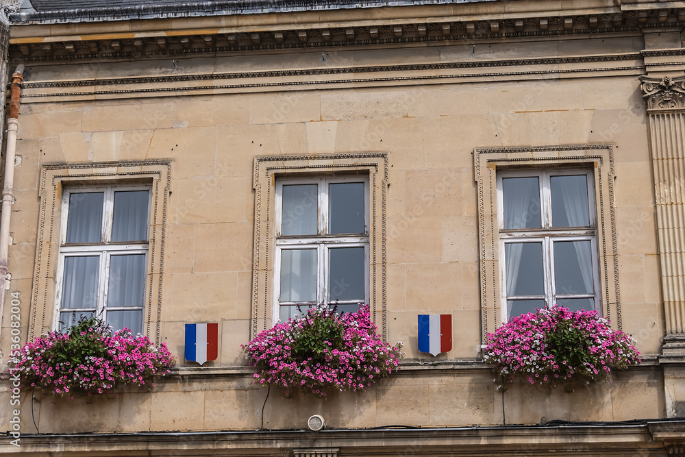 Famous historical Melun Town Hall (Hotel de Ville, 1846 - 1848). Town Hall combining neoclassical and neo-Renaissance styles, decorated with flags and flowers. Melun, France. 