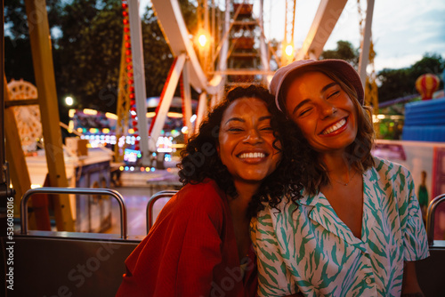 Young multiracial women riding on ferris wheel in attraction park © Drobot Dean