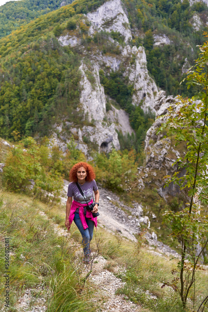 Naklejka premium Tourist with camera hiking on a trail