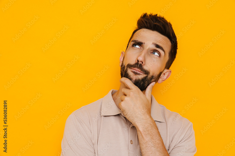 White brunette man with beard frowning while looking upward White brunette man with beard frowning while looking upward