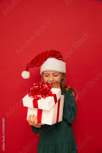 Smiling funny child (kid, girl)  holding Christmas gift box