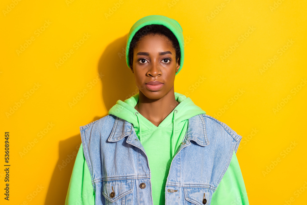 Photo of calm concentrated person look camera wear green beanie hat isolated on yellow color background Photo of calm concentrated person look camera wear green beanie hat isolated on yellow color background