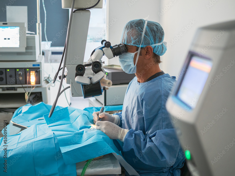 Surgeon using microscope in operating theater Surgeon using microscope in operating theater