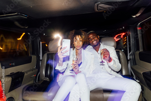 African American couple taking selfie in limousine photo