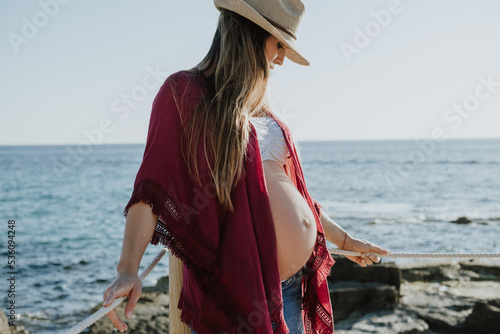 Pregnant woman resting near sea photo